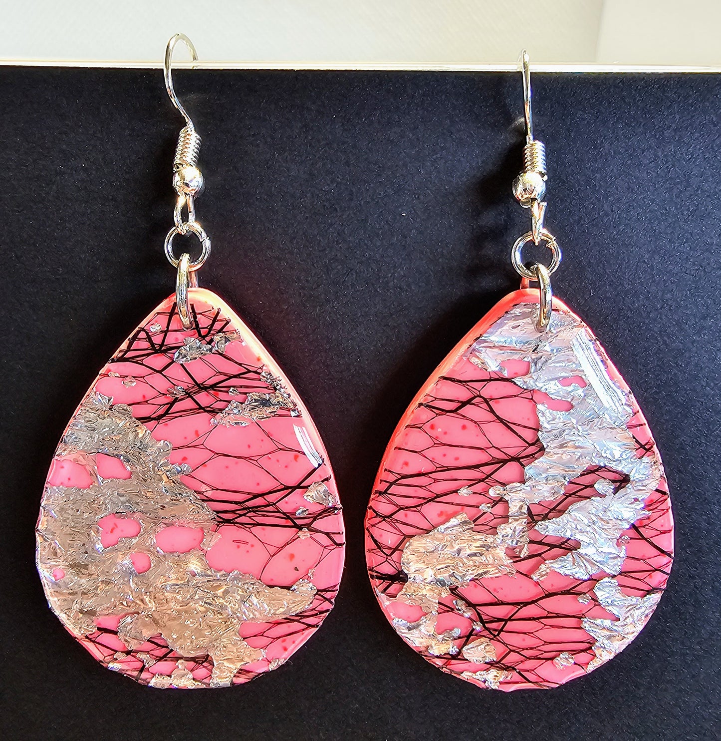 Electric pink earrings with black threading and silver flakes
